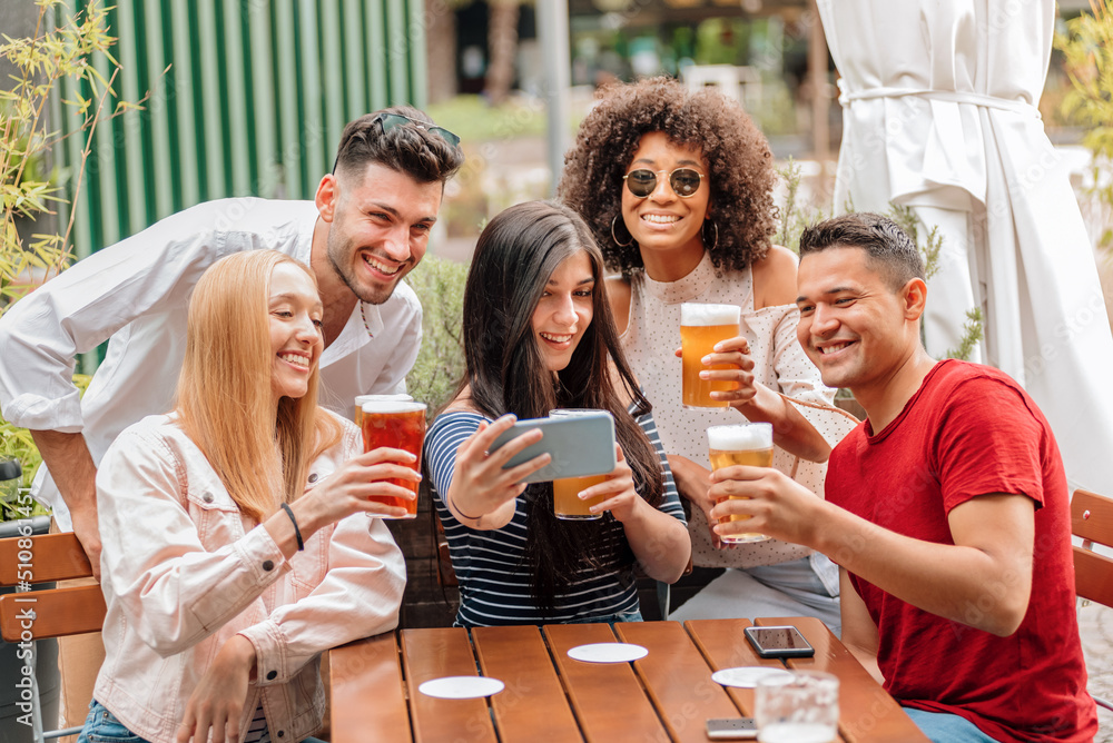 Group of diverse friends taking selfie while having a beer Group of diverse friends taking selfie while having a beer
