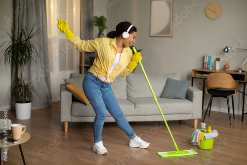African American Lady Mopping Floor Singing Having Fun At Home.