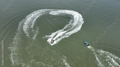 An aerial view over Gravesend Bay in Brooklyn, NY as two jet ski riders enjoys the beautiful day together. The drone camera tilted down, truck right and pan left circling the pair. photo