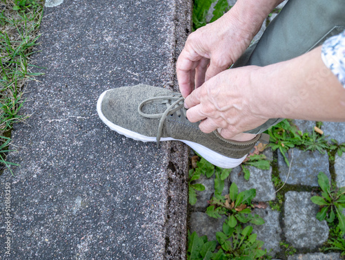 Woman tying shoelaces on sports shoes.