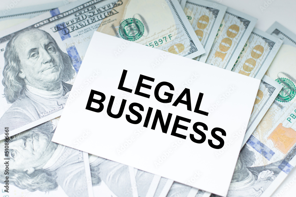 Text Legal business text on a card on the background of dollar bills, business concept Text Legal business text on a card on the background of dollar bills, business concept