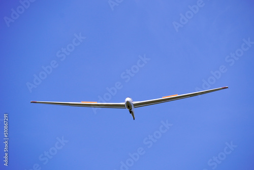 White glider with blue cloudless sky in the background. Aircraft for gliding.