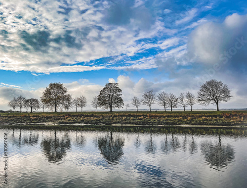 Trees and cloudscape on water reflection, Saint-Valery_sur_Somme, France photo