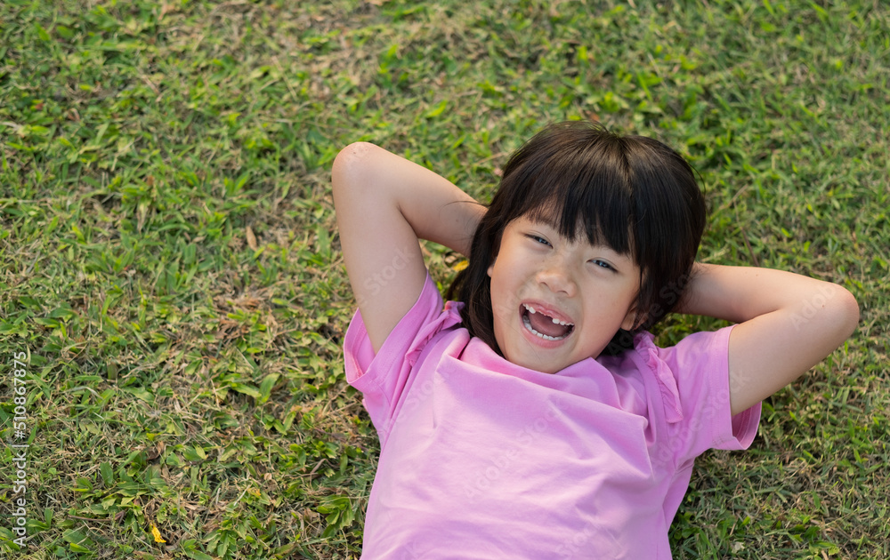 happy girl lying on the grass, play ground happy girl lying on the grass, play ground