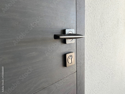 part of the gray oak wooden door with a metal lock and handle