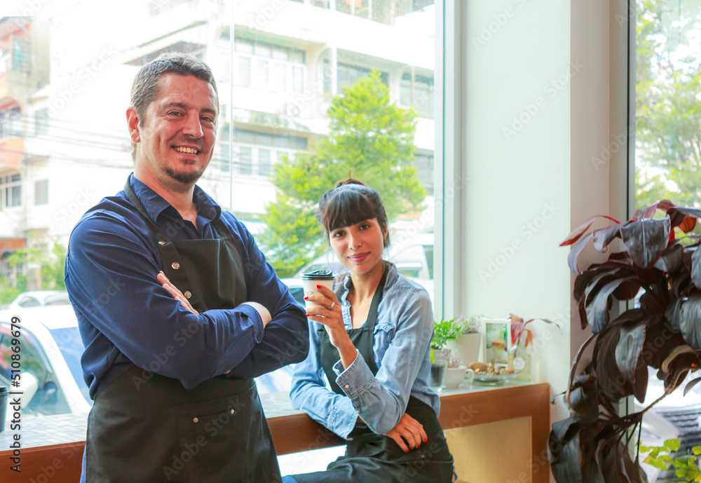 Obraz premium Caucasian young man and woman who owns a barista coffee shop. Successful talking, smiling, inside the coffee shop.