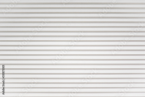 White metal roller shutter door background. Steel stripe horizontal lines of iron foldable metal sheet texture. Empty front warehouse garage abstract pattern.