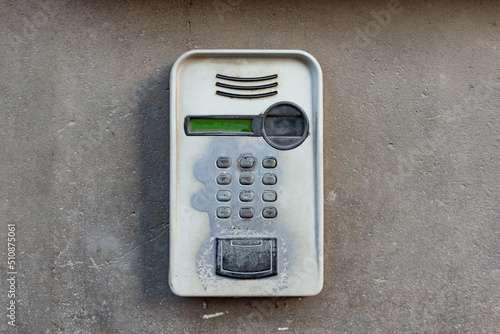 Old intercom with camera for video call mounted on a concrete wall