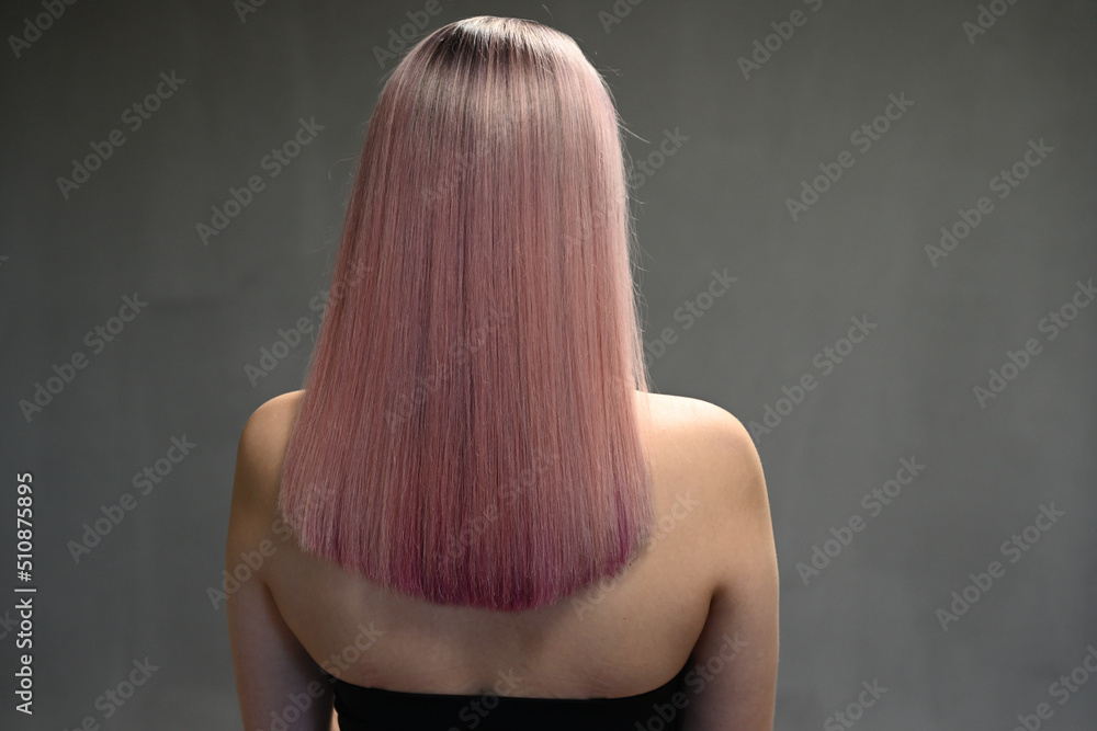Naklejka premium Back view of model with dyed hair on gray background