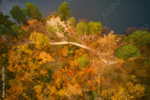 Drone view of colorful top of the forest and a lake at Autumn