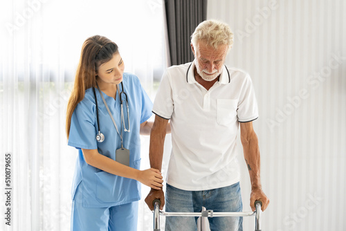 Man being cared for by a private Asian nurse at home suffering from Alzheimer's disease to closely care for elderly patients