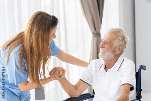 Man being cared for by a private Asian nurse at home suffering from Alzheimer's disease to closely care for elderly patients