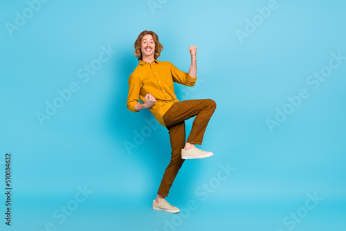 Full size photo of cheerful excited crazy male raise fists in vicotry triumph win money prize isolated on blue color background