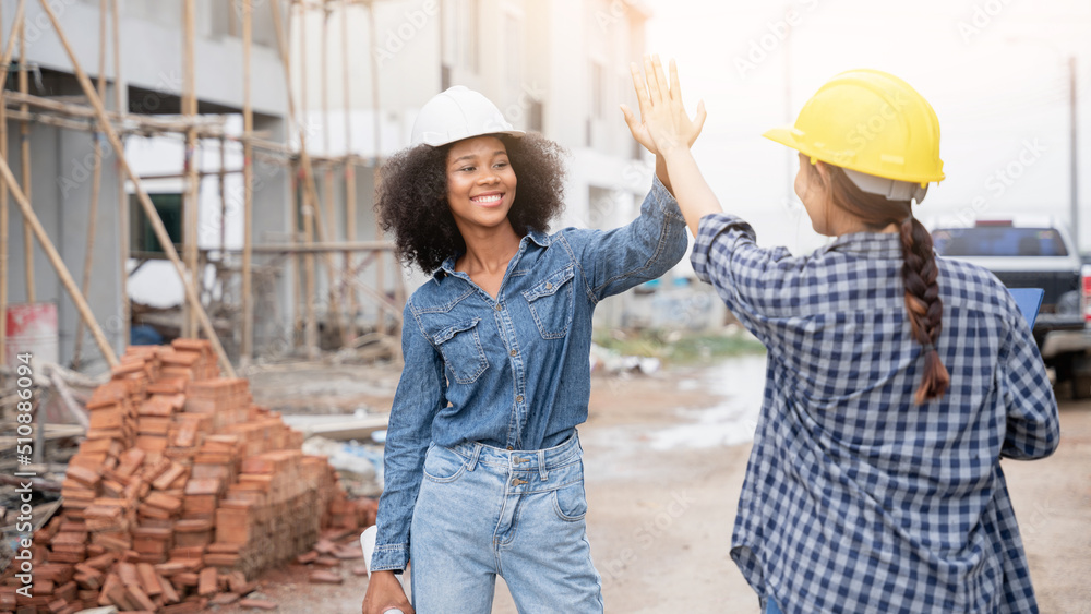 The engineer manager and forewoman construction workers shake hands on the construction site The engineer manager and forewoman construction workers shake hands on the construction site