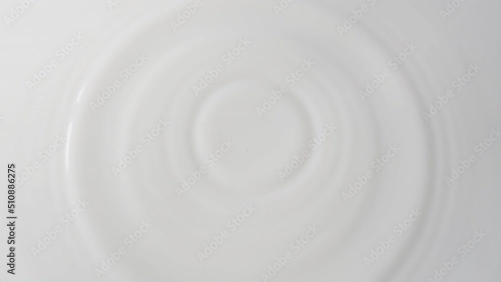 Drops of milk drip from top to center on a solid surface of milk close-up. Background of milk with falling drops. 4k raw slow motion video 60 fps. Filmed on high speed cinema camera, 1000fps. Drops of milk drip from top to center on a solid surface of milk close-up. Background of milk with falling drops. 4k raw slow motion video 60 fps. Filmed on high speed cinema camera, 1000fps.