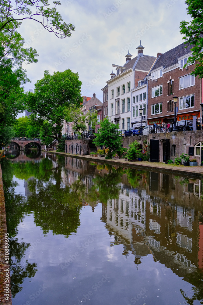 Utrecht, The Netherlands - June 07 2022: Historic houses on the Oudegracht canal with clear reflections.