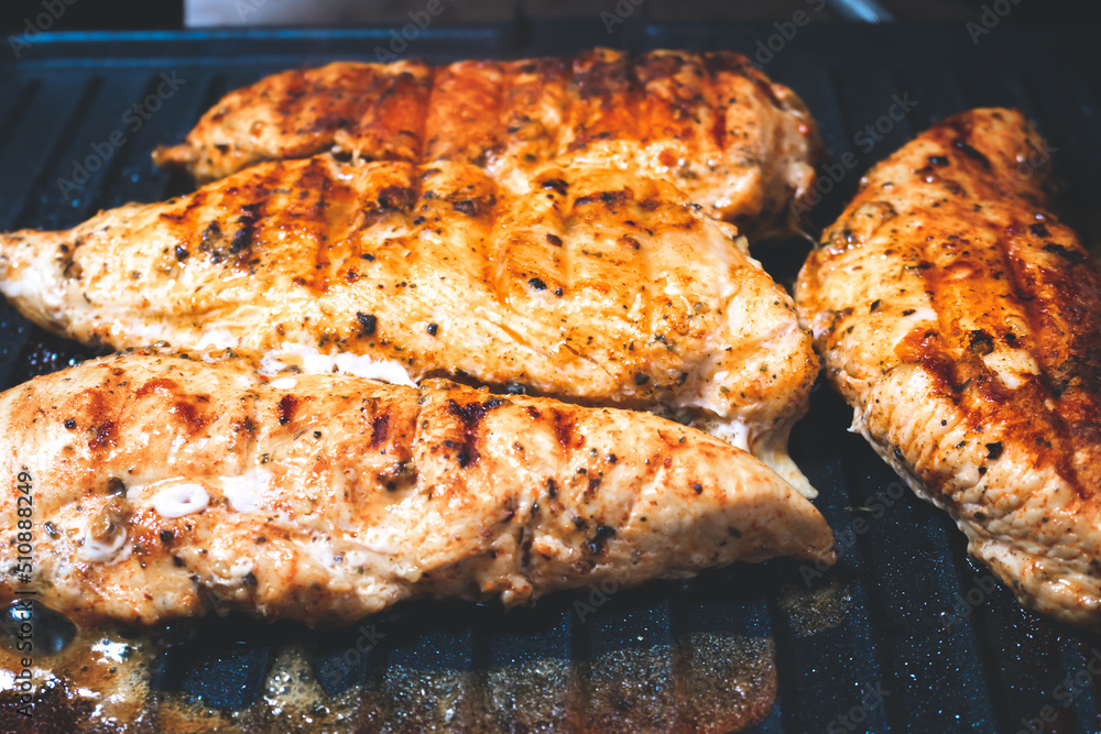 Delicious juicy chicken steak seasoned with herbs and spices is fried in a grill. Barbecue party. Delicious juicy chicken steak seasoned with herbs and spices is fried in a grill. Barbecue party.