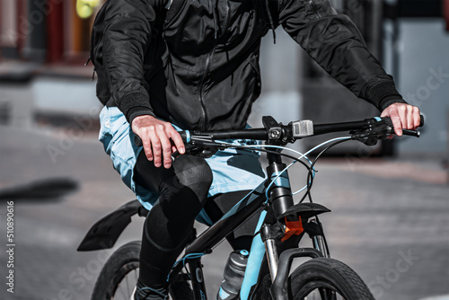 fashionable man in sportswear rides a bicycle along the city street.
