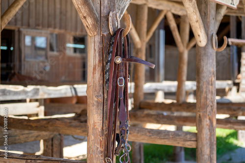 in front of a stable hangs on a post on a horseshoe hung leather thong for a horse