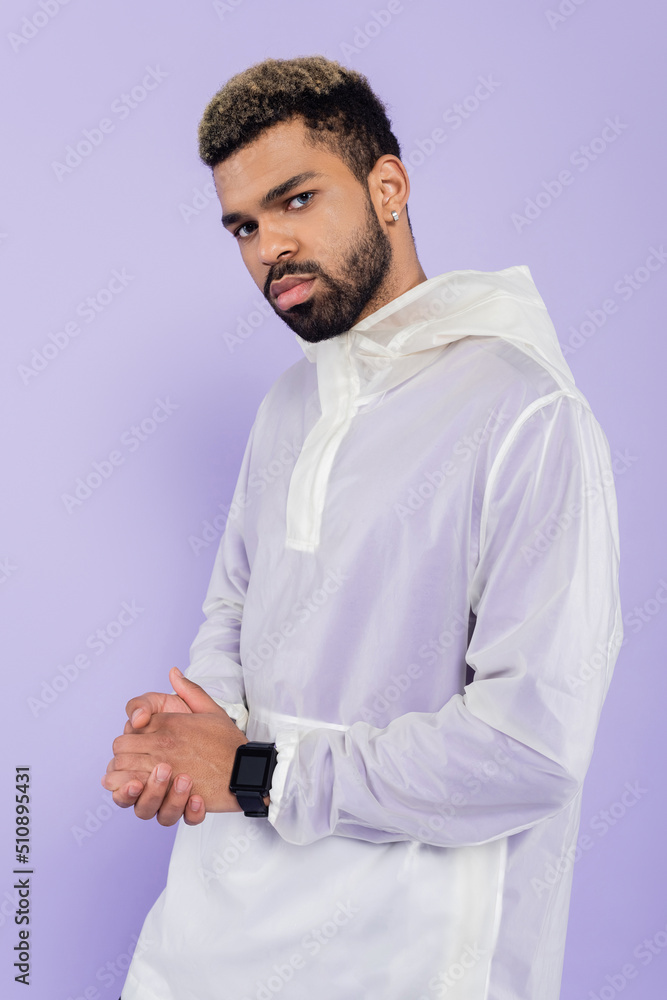 young african american sportsman with smart watch posing with clenched hands isolated on purple. young african american sportsman with smart watch posing with clenched hands isolated on purple.