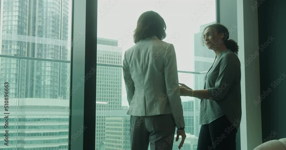 Casual Business Meeting with Digital tablet, Two Business Women in Modern Office Lobby Casual Business Meeting with Digital tablet, Two Business Women in Modern Office Lobby