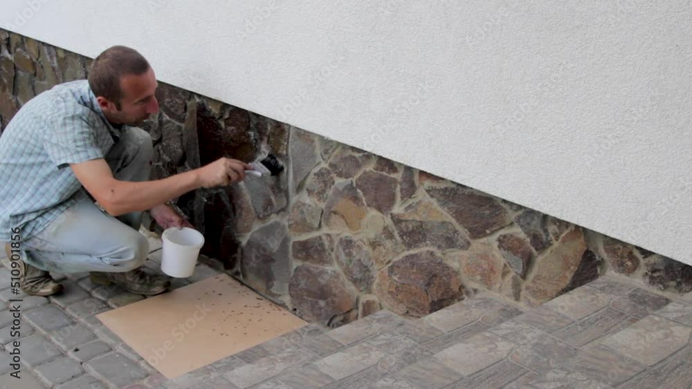 varnish the stone on the foundation of the house,man at home varnishing the foundation for beauty and protection from destruction varnish the stone on the foundation of the house,man at home varnishing the foundation for beauty and protection from destruction