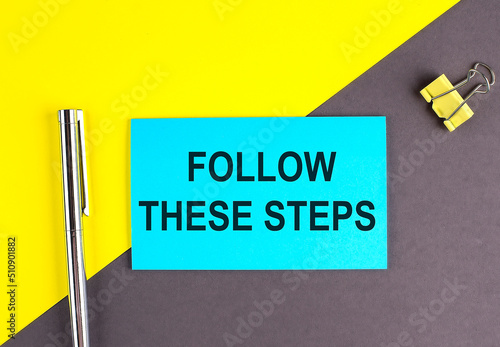 Follow these steps text written on sticky with pen on grey, yellow background, business concept