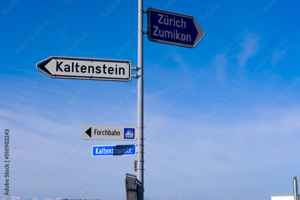 Fototapeta premium Direction signs with street lights and scenic rural landscape at village Forch, Canton Zürich, on a sunny summer day. Photo taken June 8th, 2022, Forch, Switzerland.