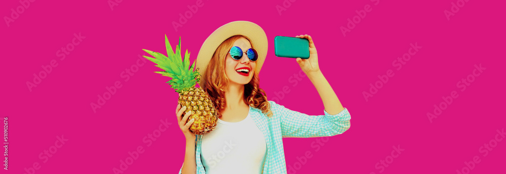 Summer portrait of happy smiling woman with pineapple taking selfie by smartphone wearing straw hat, sunglasses on pink background Summer portrait of happy smiling woman with pineapple taking selfie by smartphone wearing straw hat, sunglasses on pink background