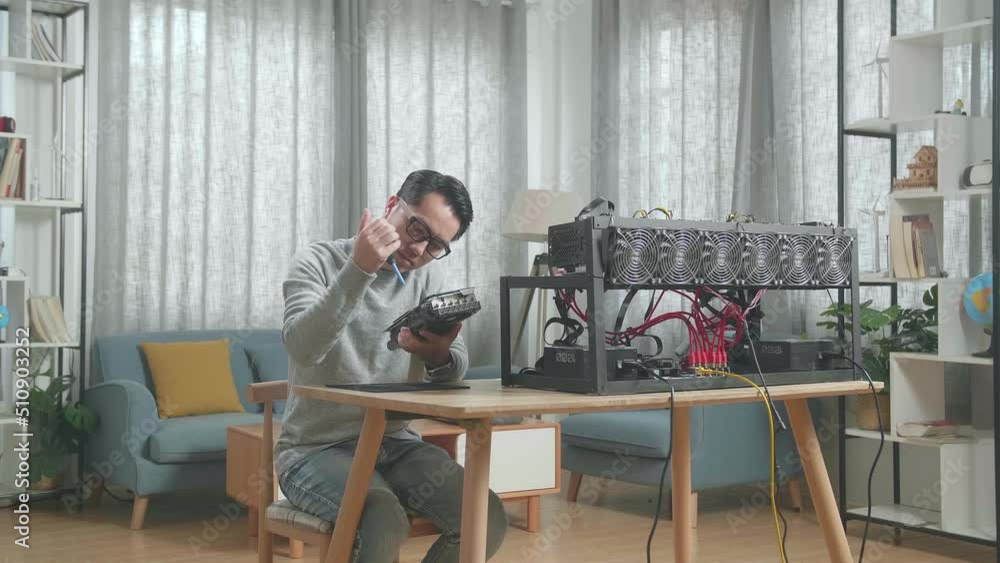 Asian Man Wearing Glasses Cleans The Graphic Card For Mining Cryptocurrency
Asian Man Wearing Glasses Cleans The Graphic Card For Mining Cryptocurrency