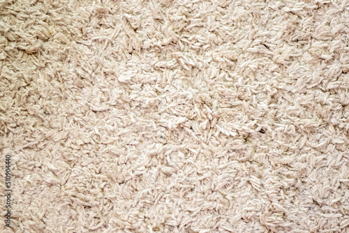 Beige background texture of towel or home carpet. Top view, flat lay. Textile texture of carpet. White or cream pile carpet. Stylish carpet on the floor in the room. Interior Design.