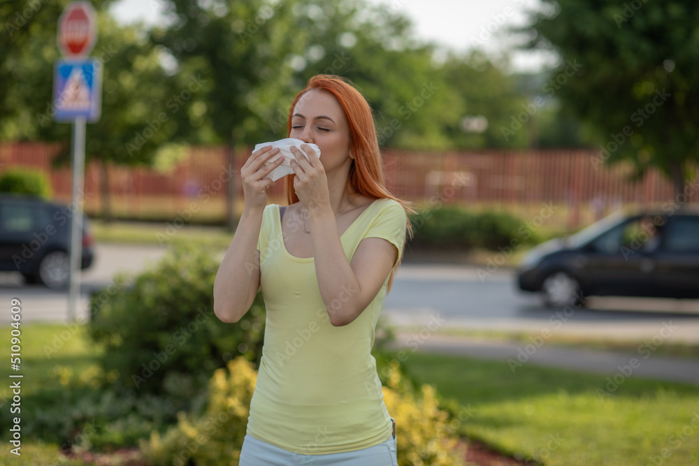 Young redhair woman sneezing in summer. Pollen Allergy symptoms Young redhair woman sneezing in summer. Pollen Allergy symptoms