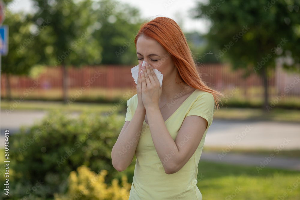 Young redhair woman sneezing in summer. Pollen Allergy symptoms Young redhair woman sneezing in summer. Pollen Allergy symptoms