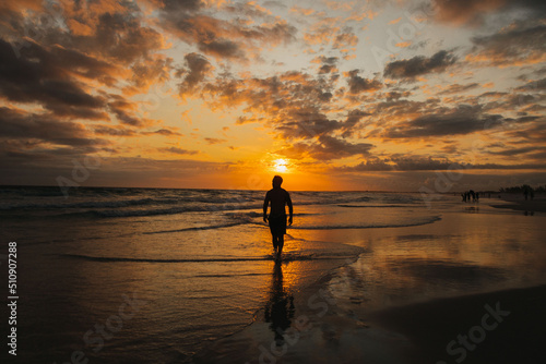 silhouette of a person on the beach at sunset © DanielViero