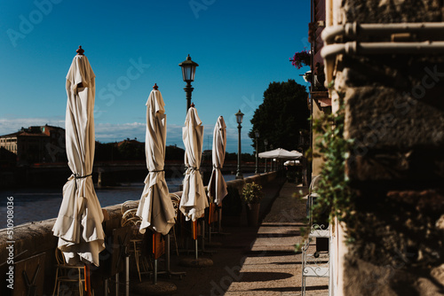Fototapeta Naklejka Na Ścianę i Meble -  Closed cafe on a street near Adidge river, Verona, Italy.