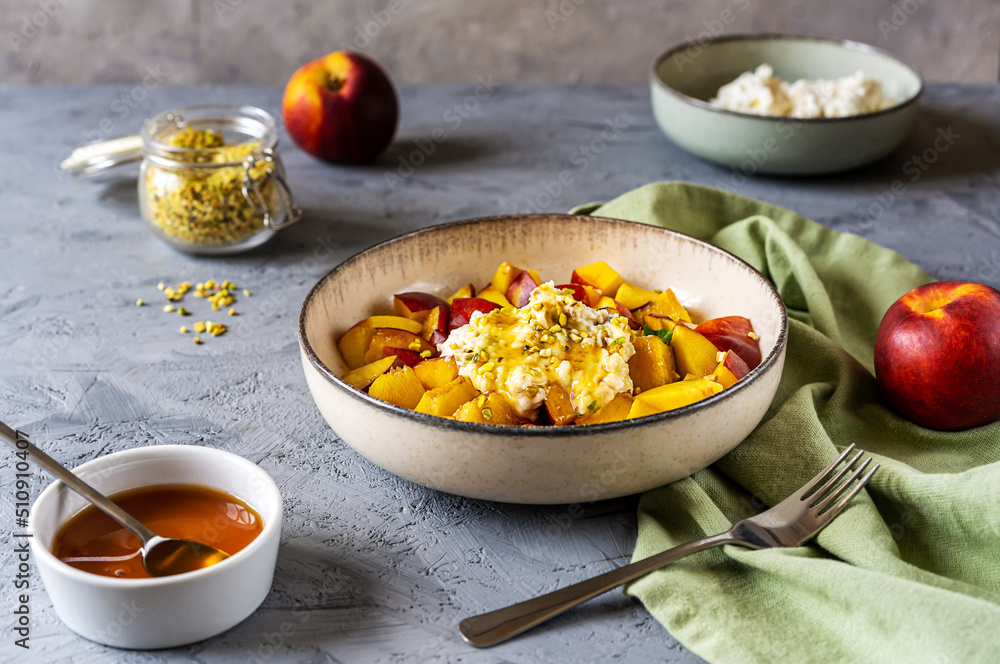 Healthy fruit salad with nectarine, ricotta cream with pistachios and honey