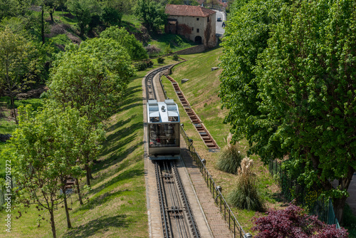 Mondovì, Italy - April 29, 2022: Funicular train rising towards of rione Piazza on hill, the funicular connects the Breo district in valley and the Piazza district upstream