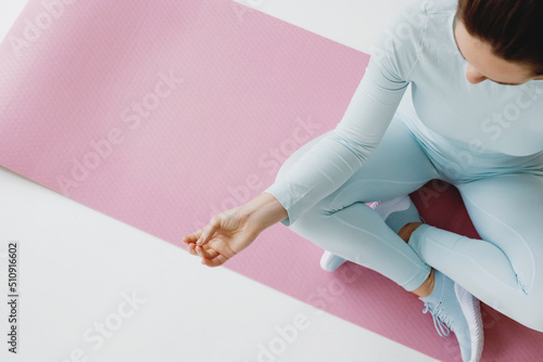 Top view of young woman meditating in lotus position.