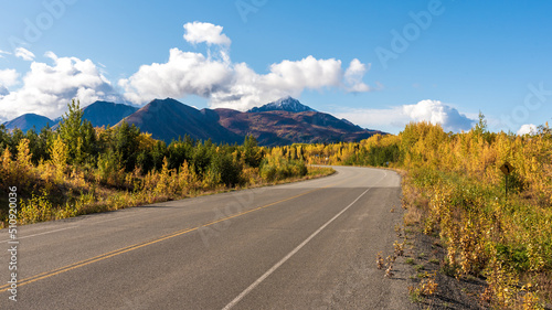 Amazing view of a road highway with fall scenes and yellow autumn colors. Yukon Territory, Alaska border in Canada. 