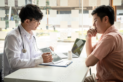 Male doctor holding tablet to explaining the results of the examination to the patient after diagnosis while talking