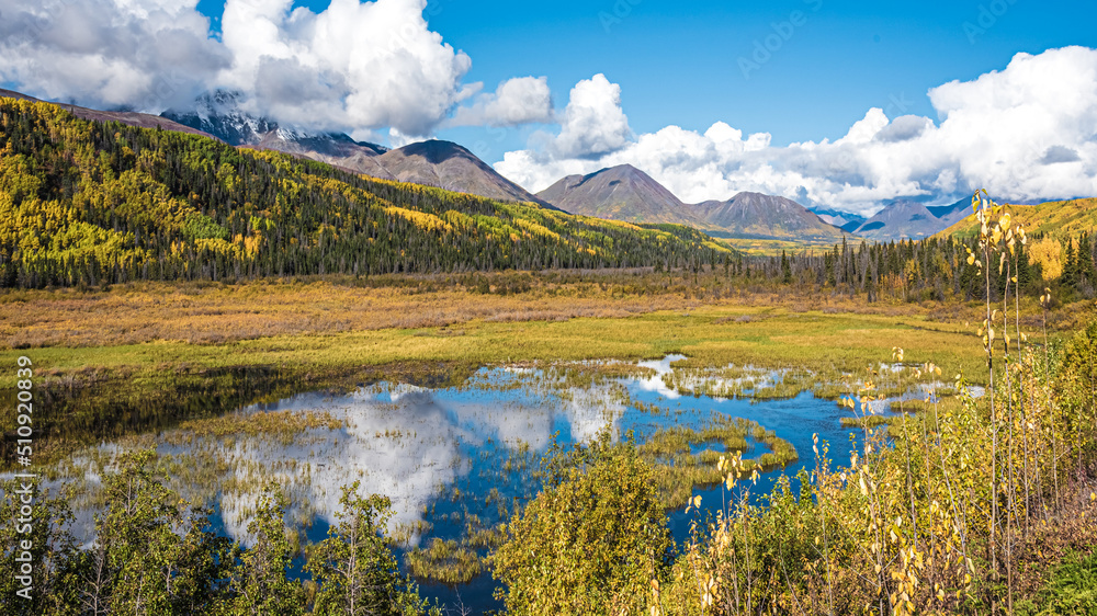 Road trip, tourism, travel themed shot heading directly towards huge mountain landscape in fall, autumn during September in northern Canada, Yukon Territory. 