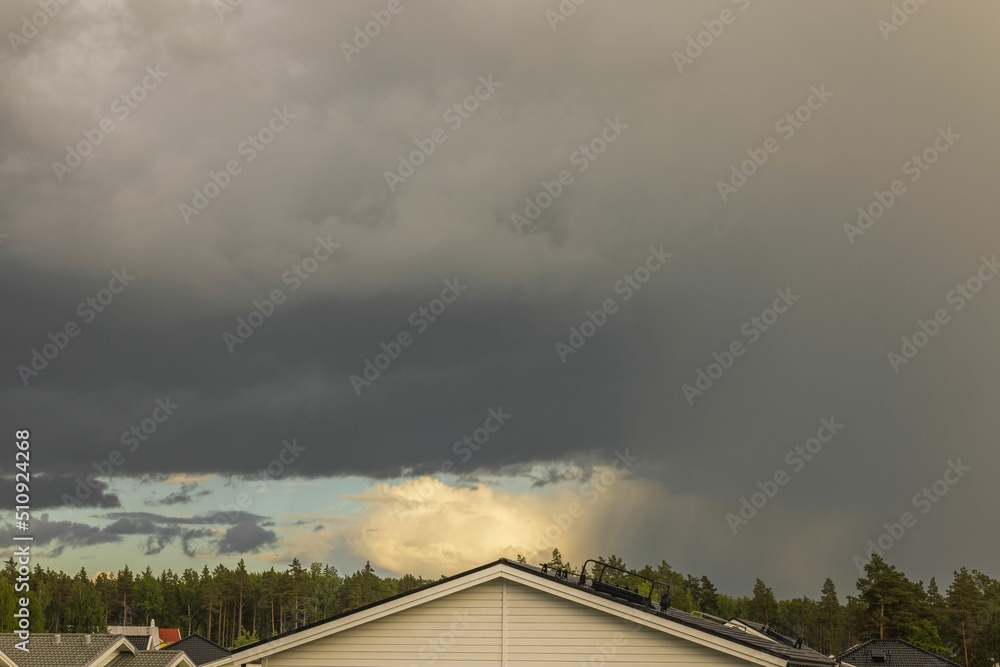 Gorgeous view of thunder sky with bit of rainbow above tops of forest trees. Sweden. Gorgeous view of thunder sky with bit of rainbow above tops of forest trees. Sweden.