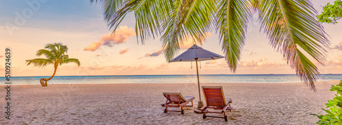 Beautiful beach panorama. Couple chairs sandy beach sunrise sea. Romantic summer holiday vacation for honeymoon tourism. Tropical sunset landscape. Tranquil palm leaves relax beach, island landscape