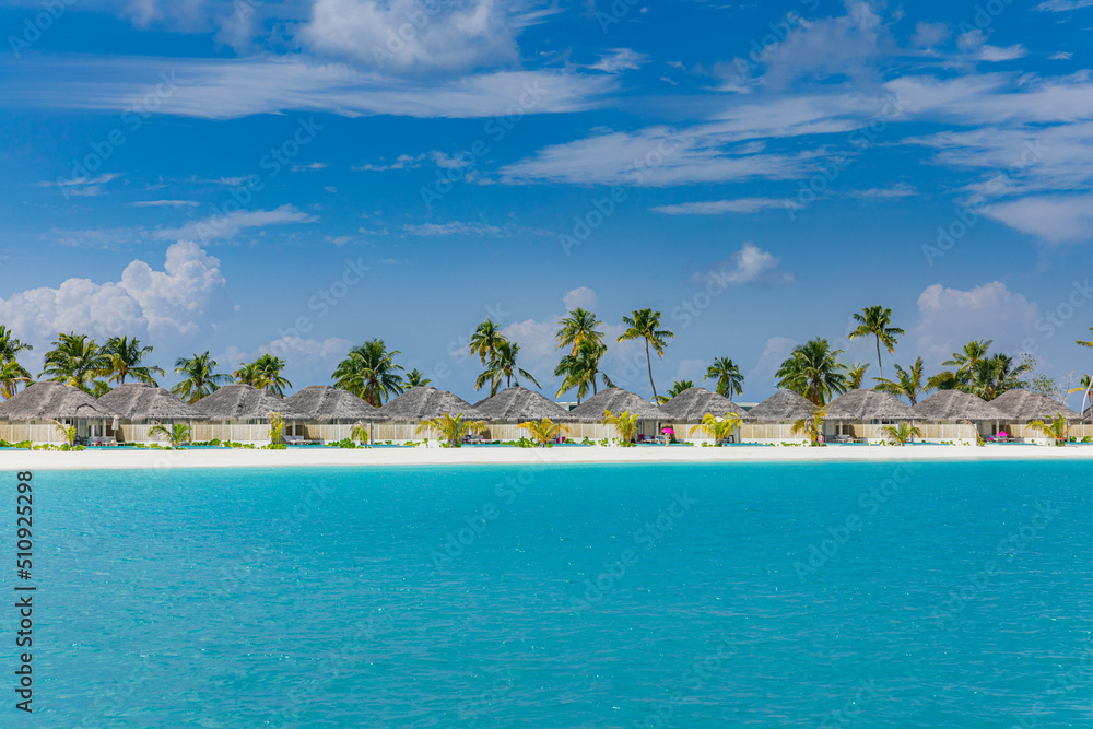 Maldives, tropical paradise, villas by the beach. Beautiful tropical beach and sea with coconut palm tree on blue sky in Maldives island. Summer travel vacation landscape. Exotic tourism landscape Maldives, tropical paradise, villas by the beach. Beautiful tropical beach and sea with coconut palm tree on blue sky in Maldives island. Summer travel vacation landscape. Exotic tourism landscape