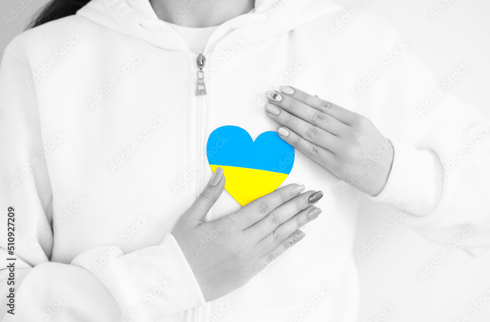 The flag of Ukraine - yellow and blue postcard in women's hands The flag of Ukraine - yellow and blue postcard in women's hands