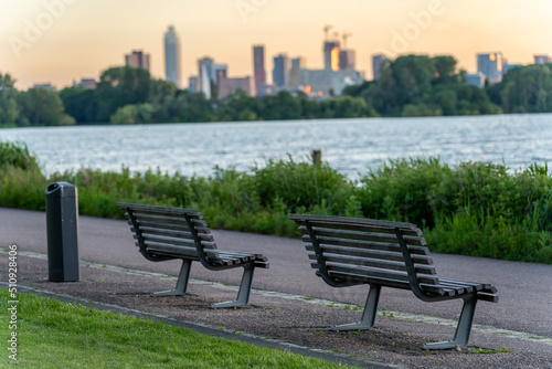 Empty bench in the park along the lake Kralingen, with blurred out skyline of Rotterdam in the background