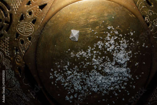Maldon sea salt flakes with single pyramid shape salt crystal on hexagonal brass