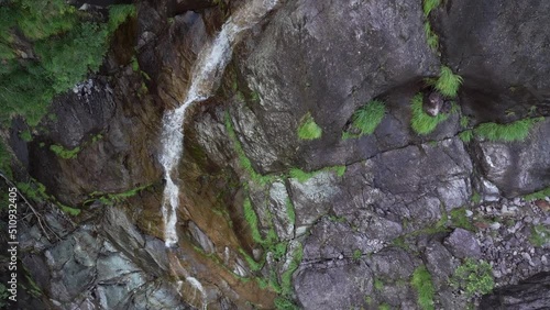 Aerial drone view of Fondra waterfall, the highest italian water jump. Flow of water trough rocks and trees in the forest in spring. Val Brembana, Bergamo, Italy. photo