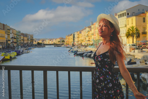 Young asain woman in summer dress standing on bridge in Sete, one of the top destination in Occitanie region, south of France © nonglak