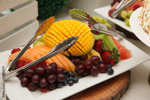 Exquisite fruit platter with tongs